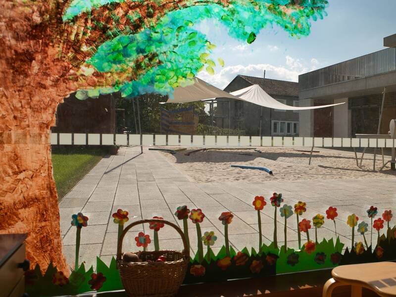 Ein Fensterbild mit Bäumen und Blumen vor einem großen Spielplatz im Außenbereich